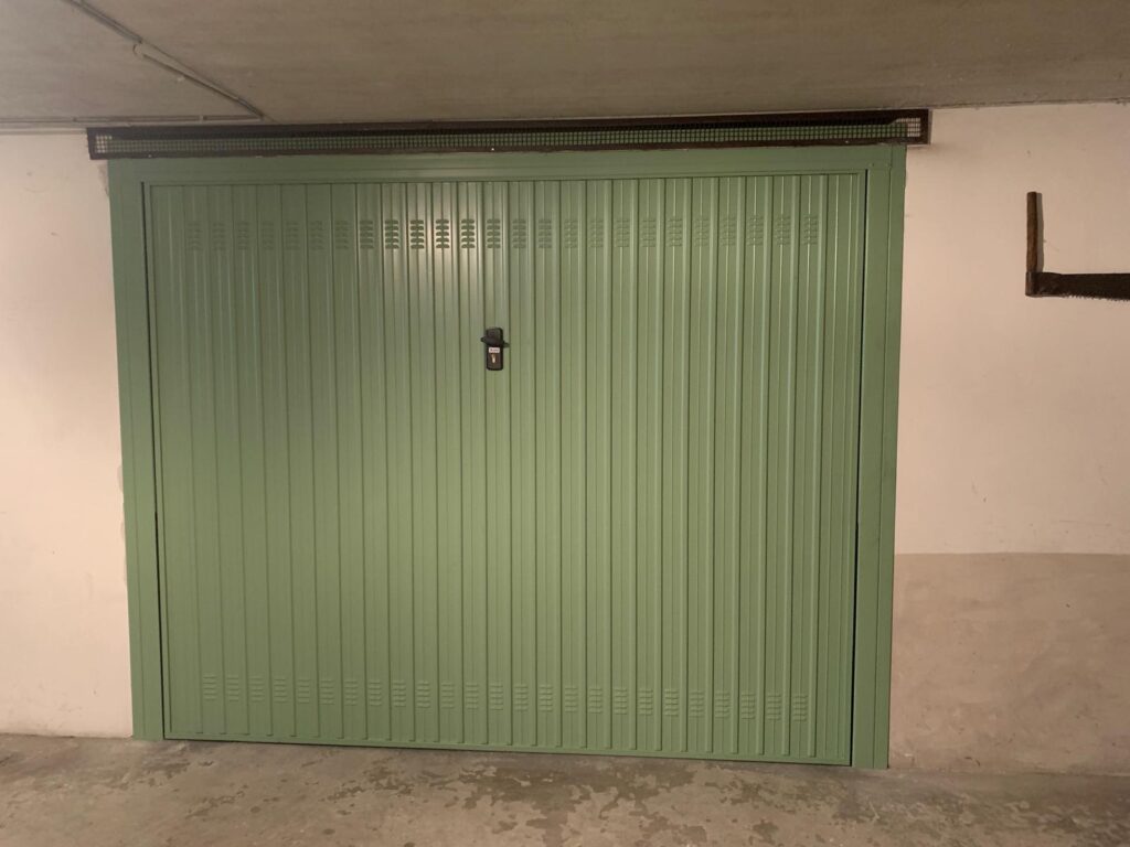 Portone garage basculante con feritoie per l'aerazione e apertura manuale